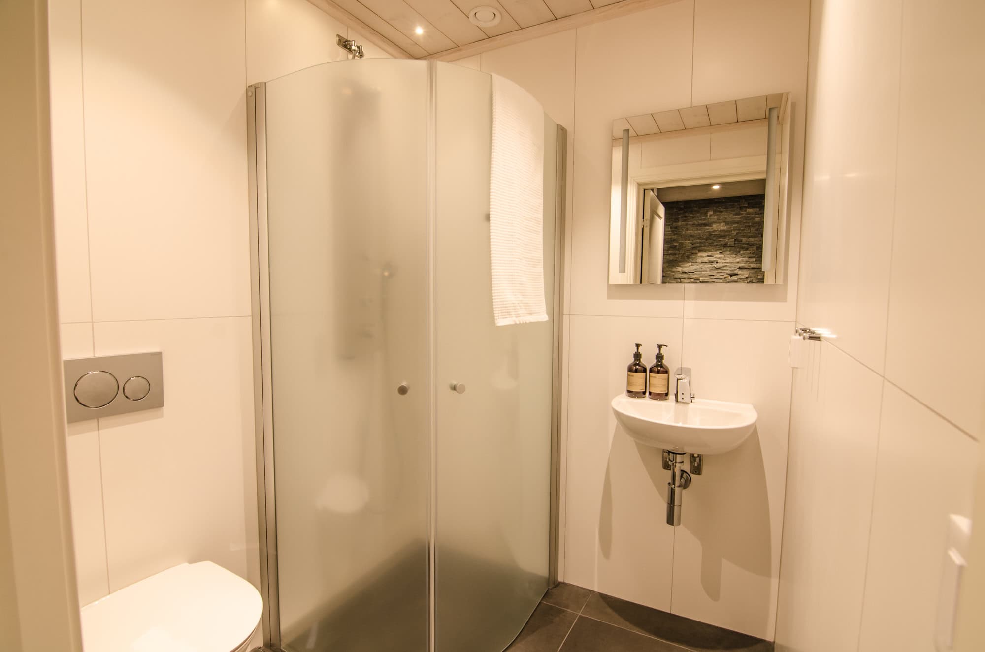 Modernt badrum med dusch och spegel.