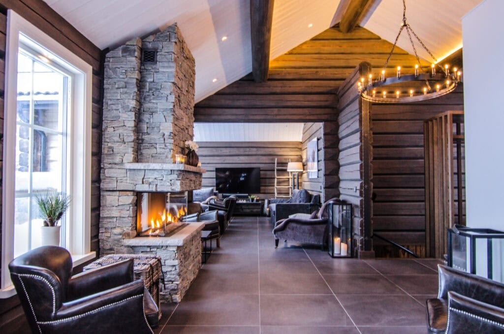Stenklädd eldstad och lounge i exklusiv fjällstuga i Sälen
