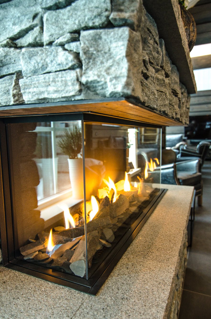 Lyskamin med stenskärm, modern inredning, mysig värmekälla för inomhus- och utomhusbruk, energioptimerad, stilren design.