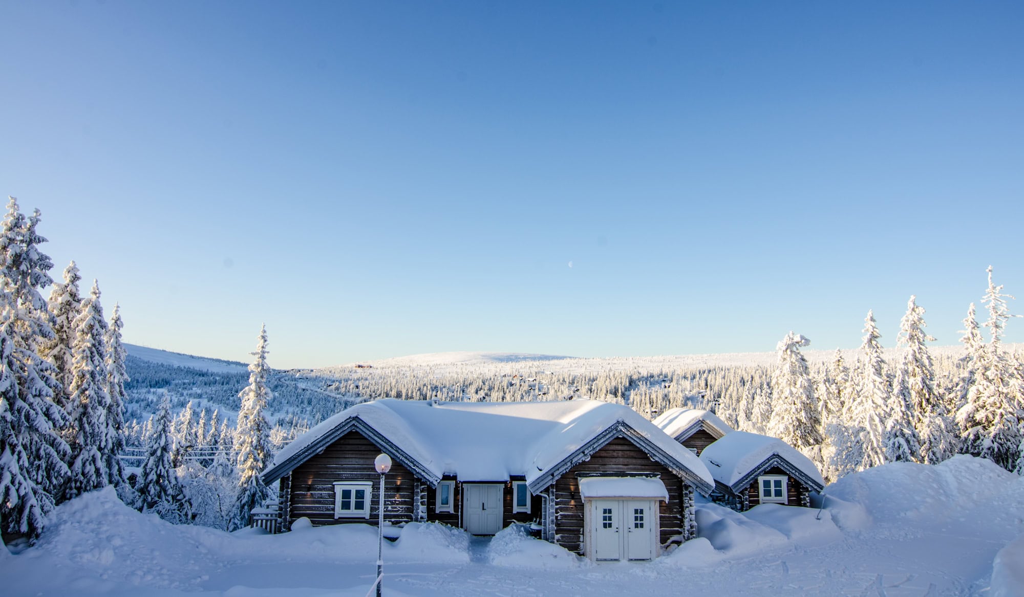 Snöiga stugor i vinterlandskap