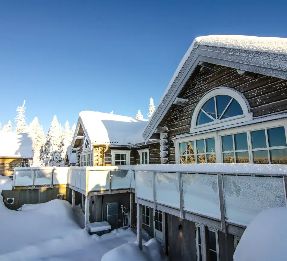 Lyxig fjällstuga i Sälen med snötäckta tak och solig vinterdag.