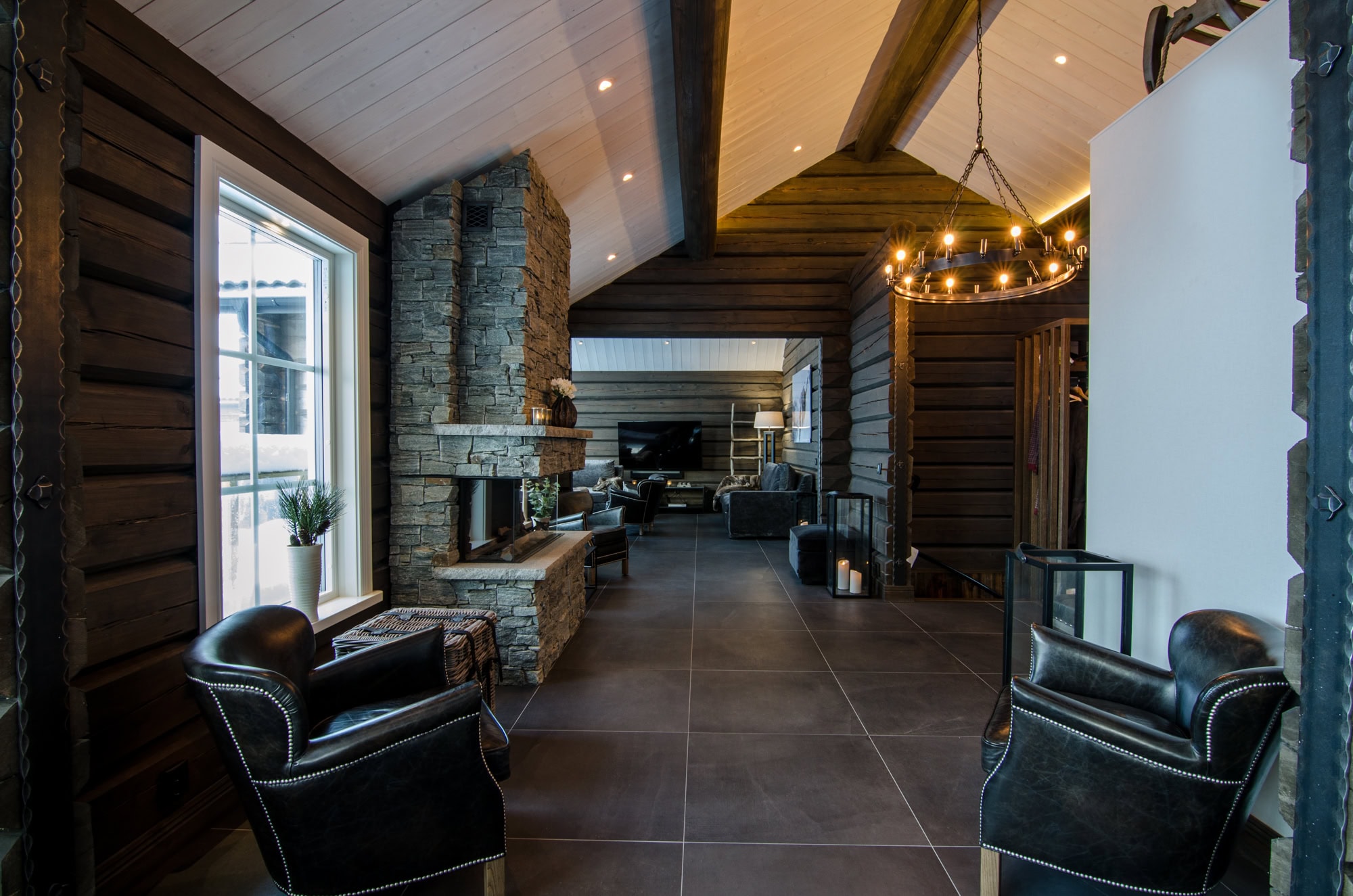 Lyxig träinredning med modern öppen planlösning och mysig värmande braskamin, idealisk för avkoppling och samvaro i en exklusiv salongmiljö.