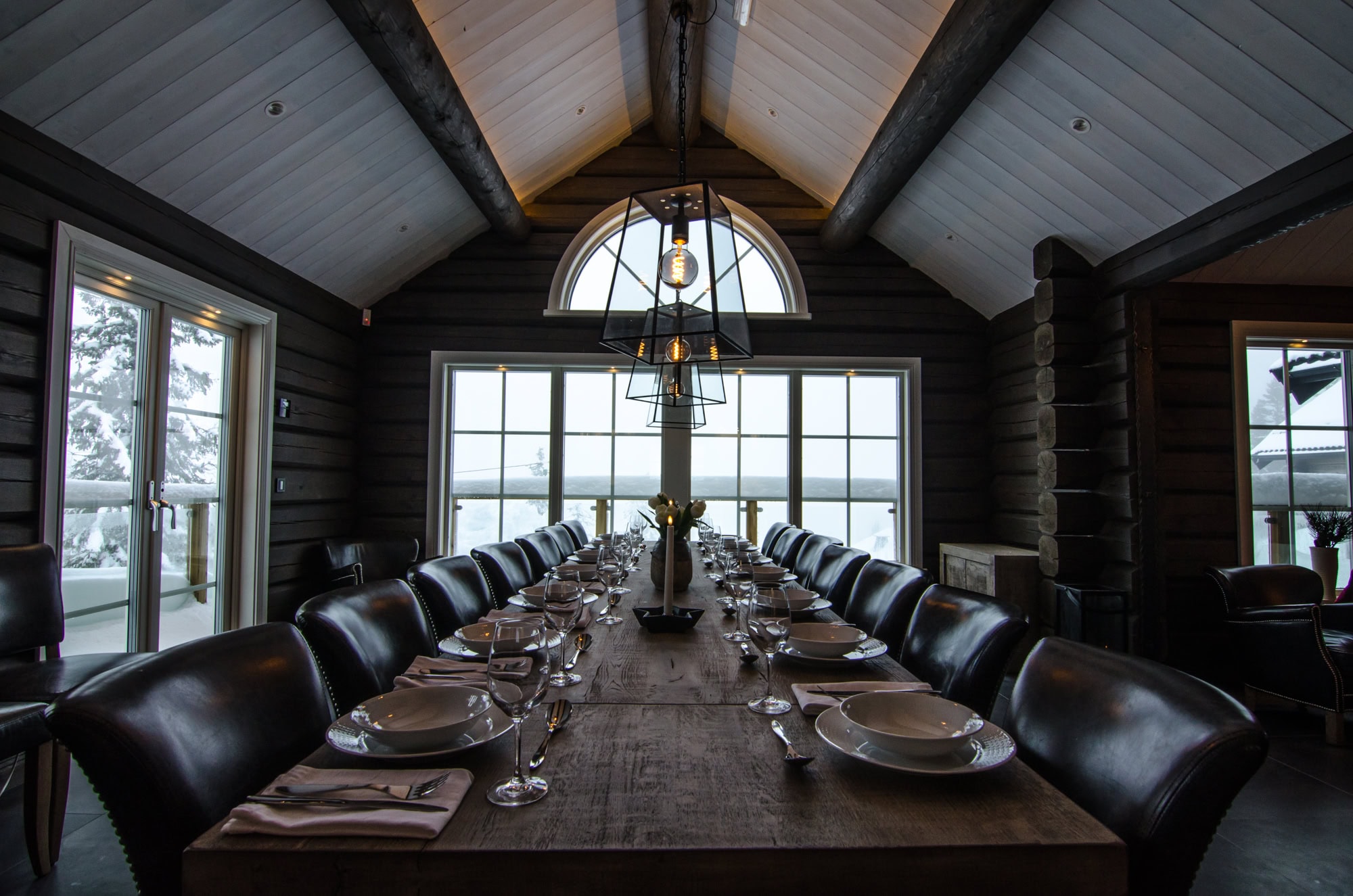 Rustik matsal i trästuga för exklusiv middagsupplevelse med utsikt mot snötäckta landskap. Perfekt för boende oförglömliga stunder i naturen.