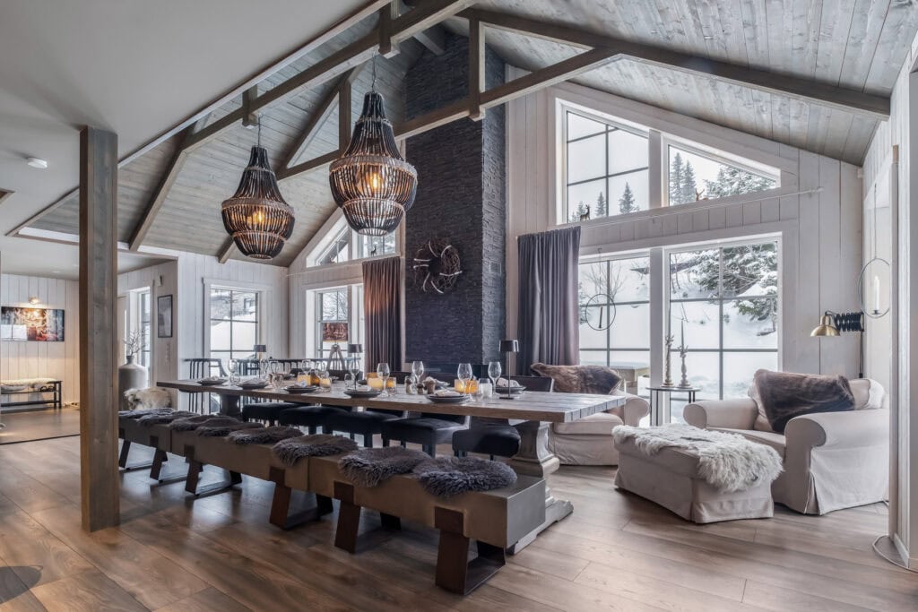 Moderne spisestue i et sommerhus med mye lys, trevegger og koselige detaljer i skandinavisk stil, perfekt for avslapping og sosialt samvær.