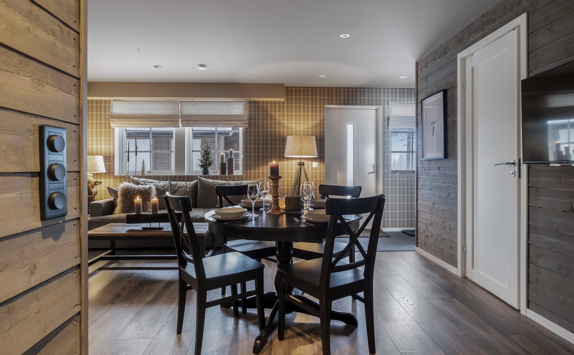 Mysig och modern vardagsrum och matsal i rustik skandinavisk stil med träväggar och skandinavisk design, perfekt för avkoppling och sociala tillfällen i ett saltbad med hög kvalitet.