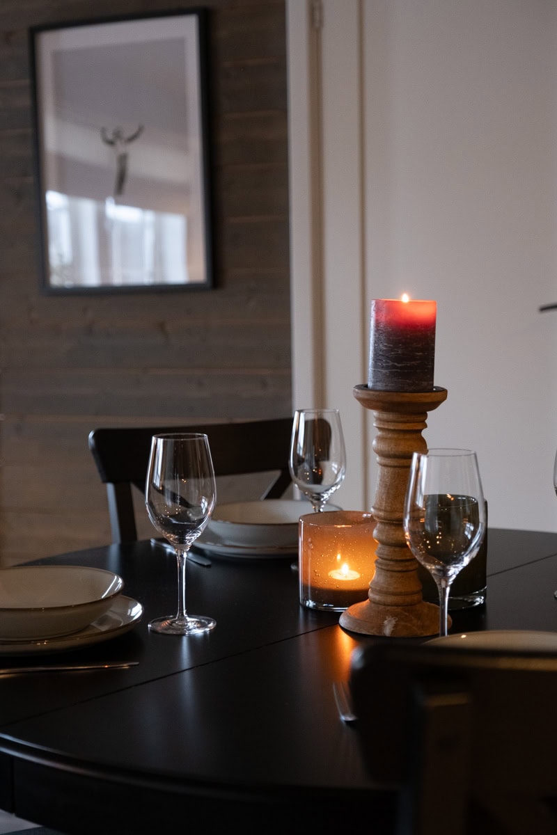 Rustik och modern bordsdekoration med ljuslyktor och stearinljus i trädetaljer, perfekt för mysiga middagar och festliga tillfällen. Passar för optima och inredning med svensk landsbygdsenkänsla.