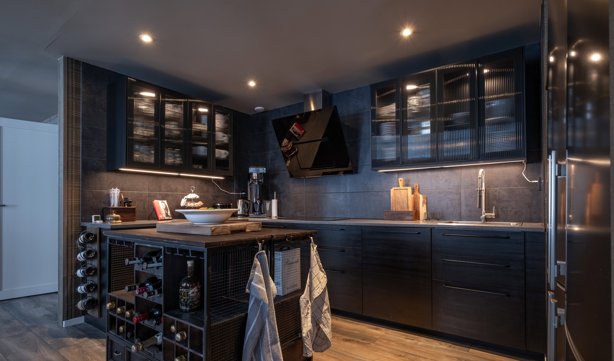 Modern kök med svarta skåp och rustikt köksö, perfekt för social matlagning och inredning i stilren design, utmärkt för optimal funktion i hemmet.