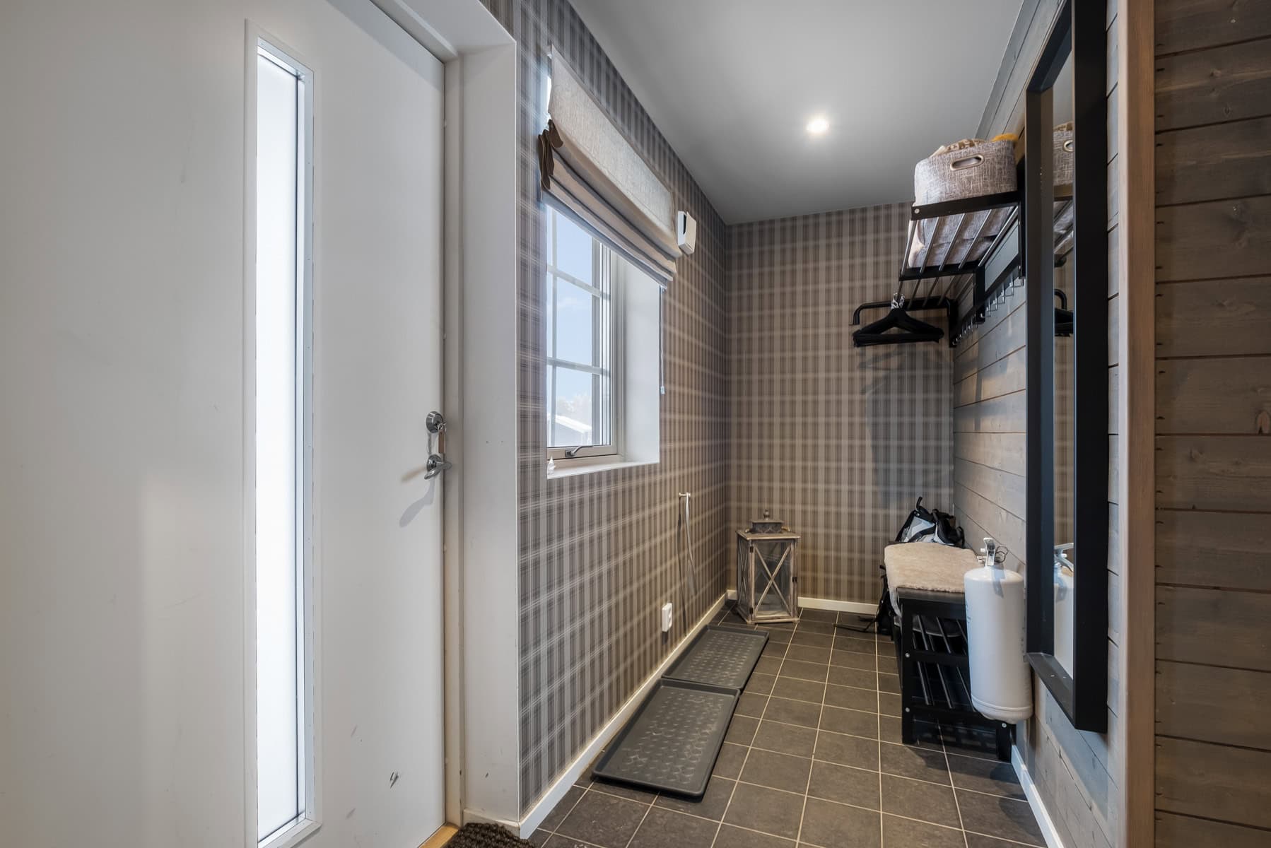 Bekvämt inrett hallutrymme med funktionella förvaringslösningar och rustika träinslag, perfekt för organisering och tidig uppstart på dagen.