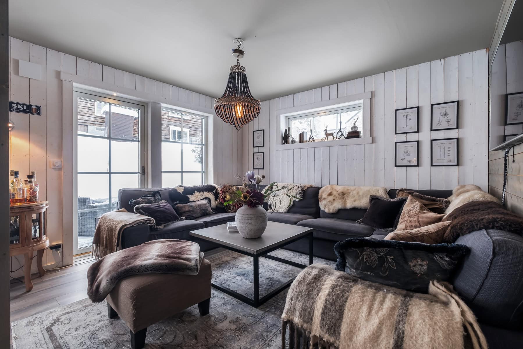 Lyxig och mysig vardagsrumsmiljö med skinnmöbler, dekorationer och trämöbler, perfekt för avkoppling och sociala stunder i ett hemtrevligt hem.