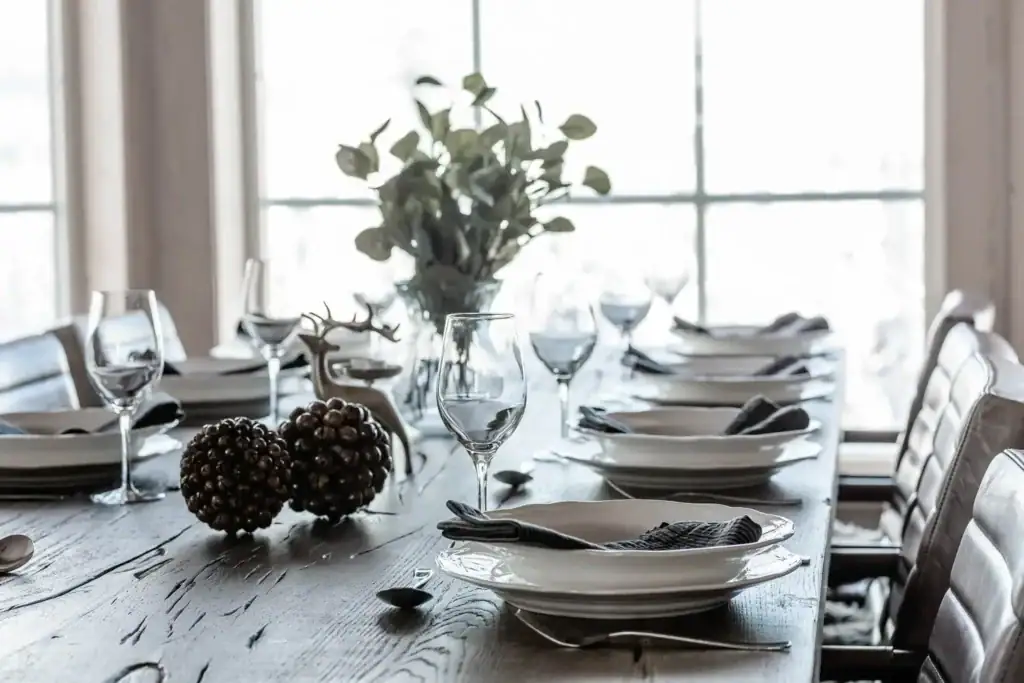 Närbild på elegant dukat matbord med glas, tallrikar och dekor.