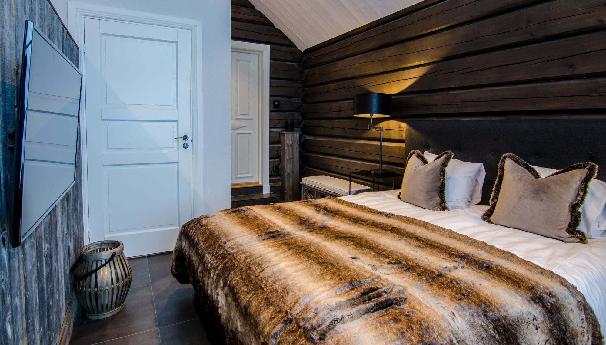 Elegant hotellrum med trapprad vägg, bekväm säng med pälsbädd och moderna lampor för avkopplande vila i salengodset.