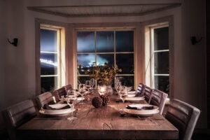 Langbordsdækning med udsigt til oplyste skiløjper i Sälen om aftenen