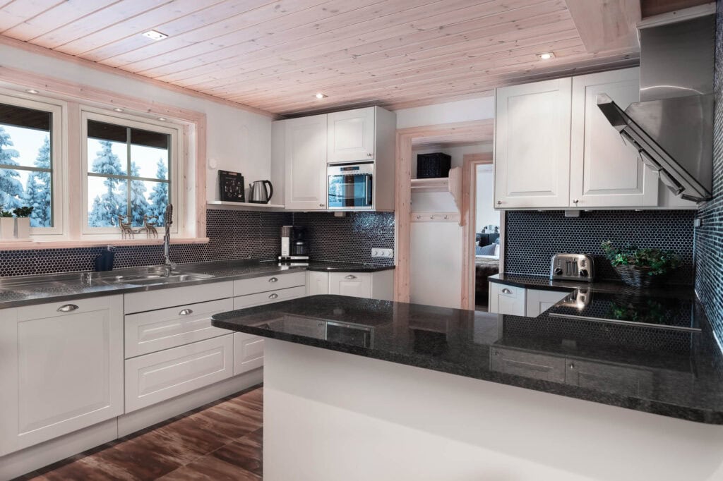 Modernt kök i fjällstuga i Sälen med utsikt över snöklädda träd