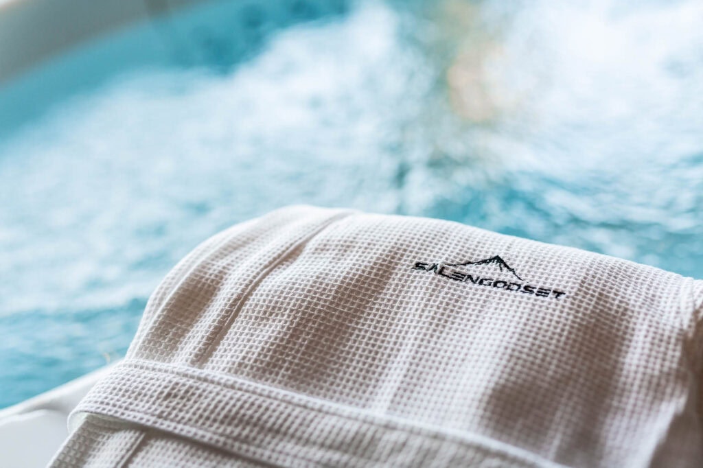 Morgonrock med Sälengodset-logotyp vid jacuzzi – spa och avkoppling i Sälen