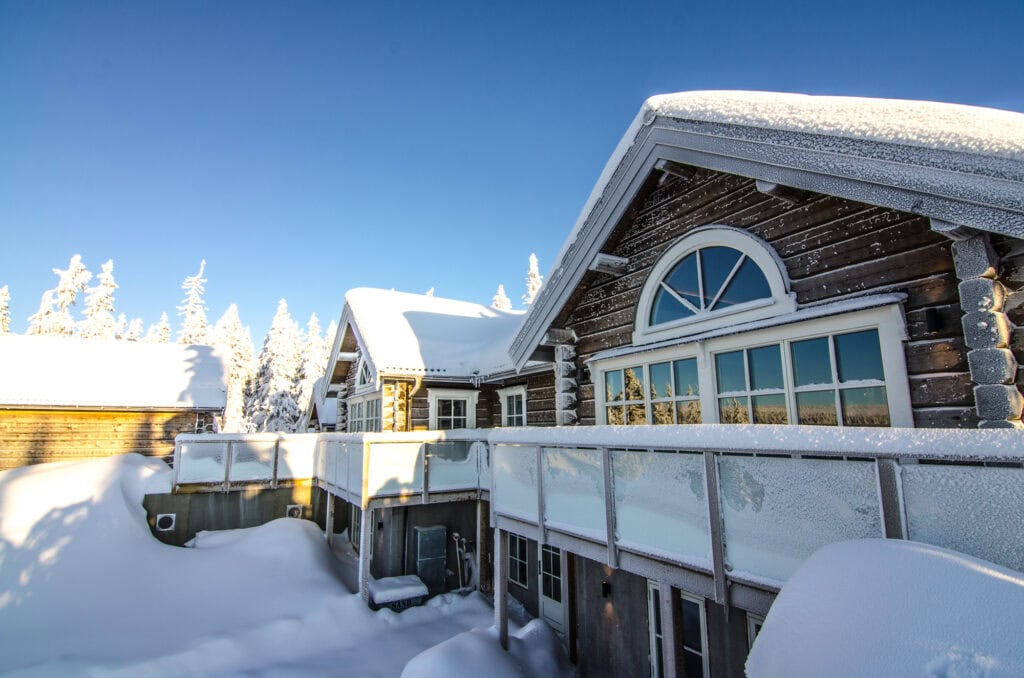 Fjällstuga i Sälen täckt av snö en solig vinterdag