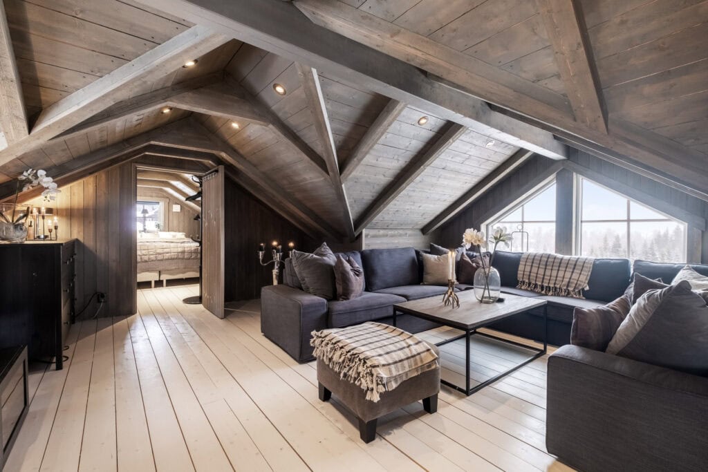 Mysigt loft i fjällstuga i Sälen med soffa och utsikt över fjällskog