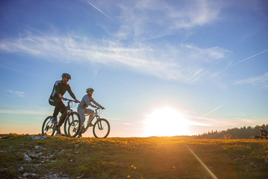 Två cyklister på fjälltur i Sälen en sommarkväll i solnedgång