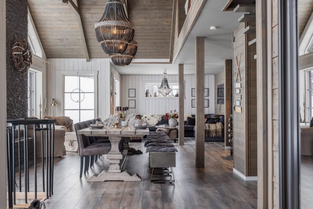 Ljust & rymligt vardagsrum med modern design, träväggar & ljuskronor, perfekt för avkoppling & sociala sammanhang. Naturliga material och stilfull inredning skapar en varm atmosfär.