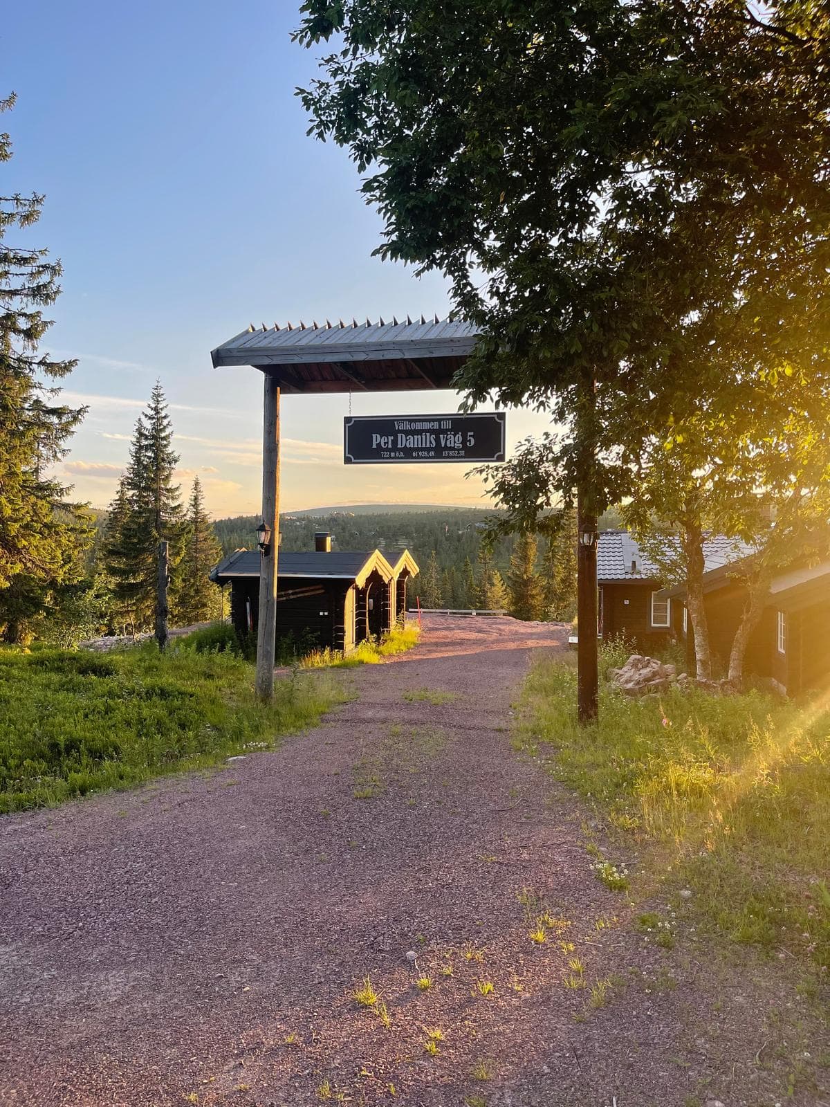 Vacker väg med stugor och solnedgång