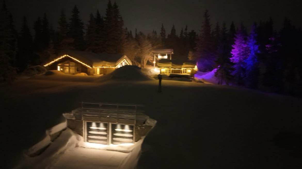 Vinterlandskap med upplysta stugor