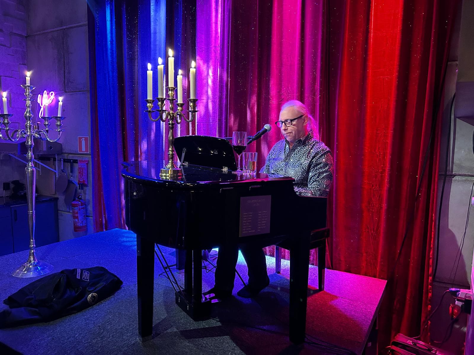 Pianist spelar på scen med ljus.