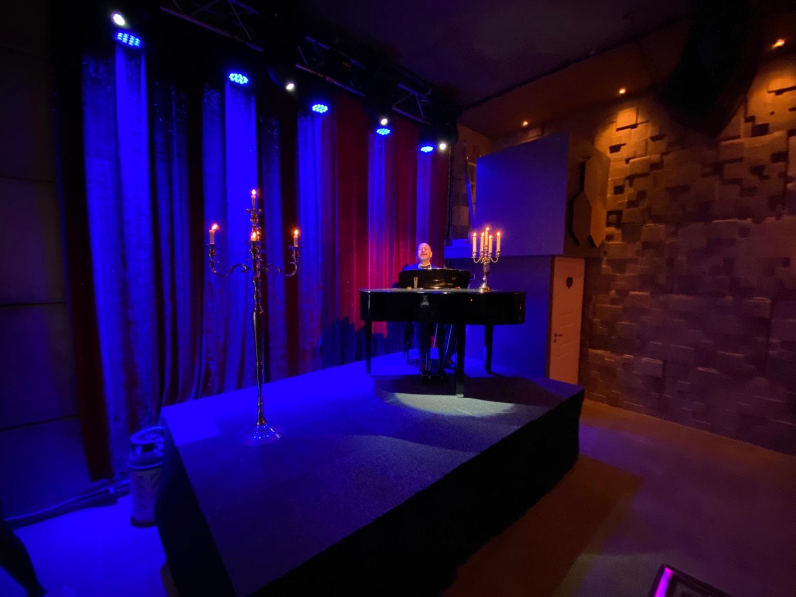 Piano på scen med ljus och dekorationer.