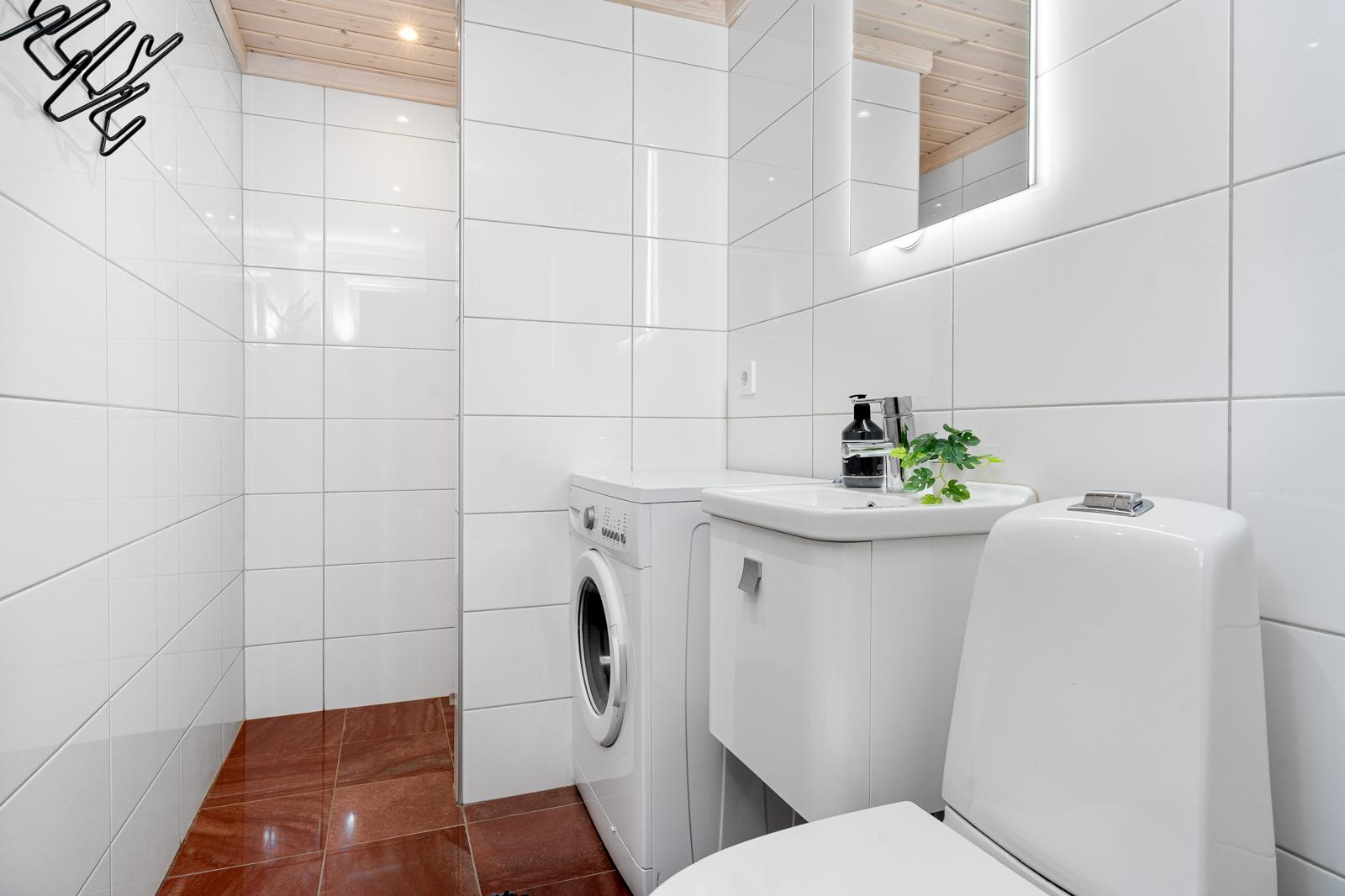 Ljust och modernt tvättrum med toalett