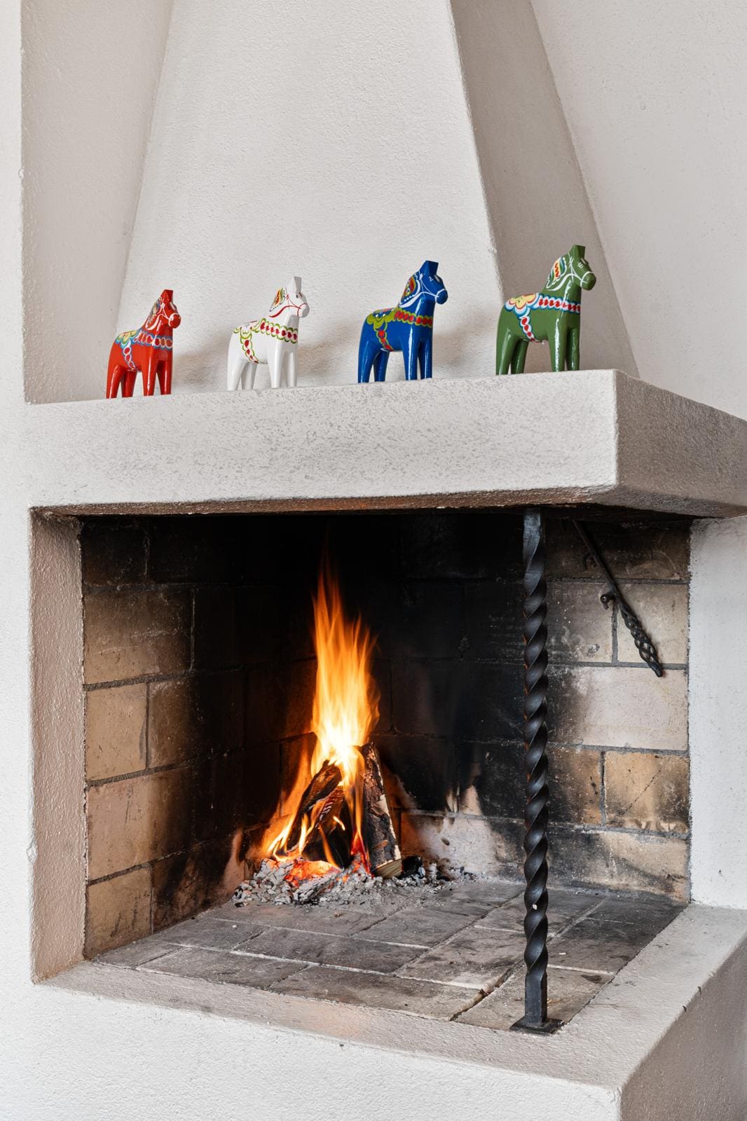 Eldstad med färgglada hästar ovanför