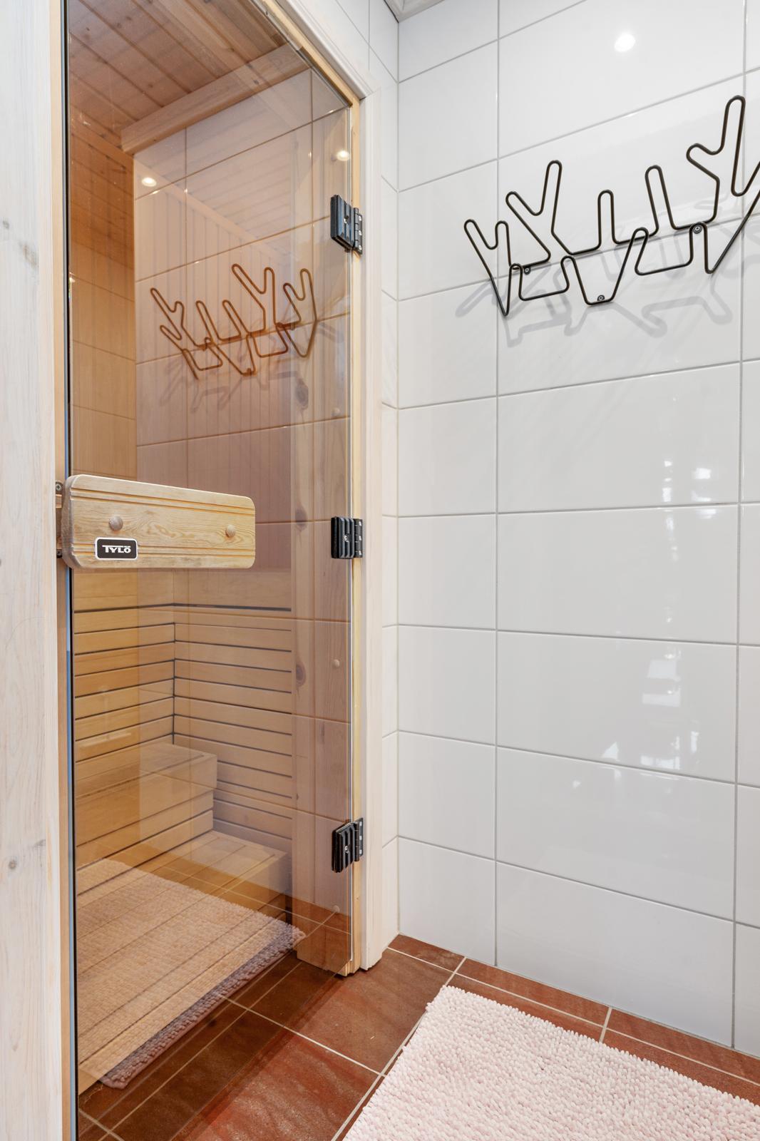 Modern bastu med glasdörr och krokar