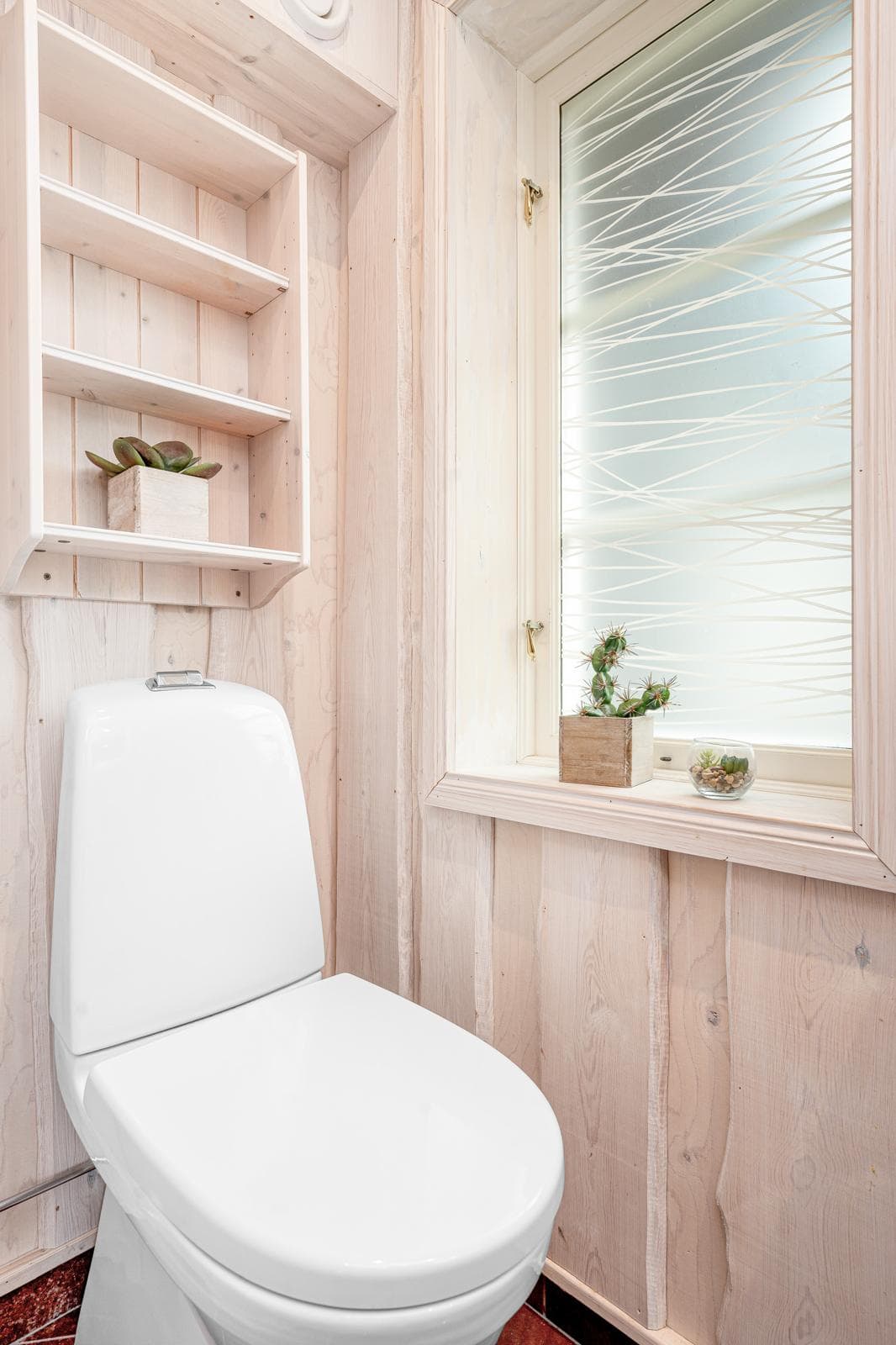 Ljust badrum med toalett och fönster