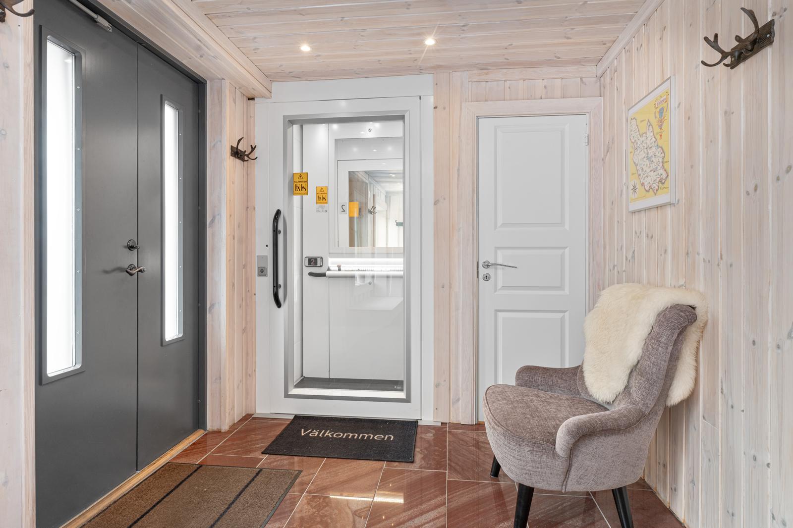 Modern entré med hiss och fåtölj