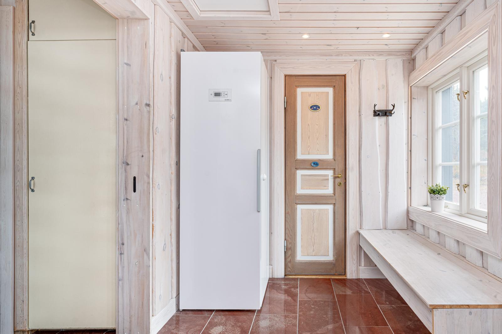 Ljust kök med vit kyl och bänk.