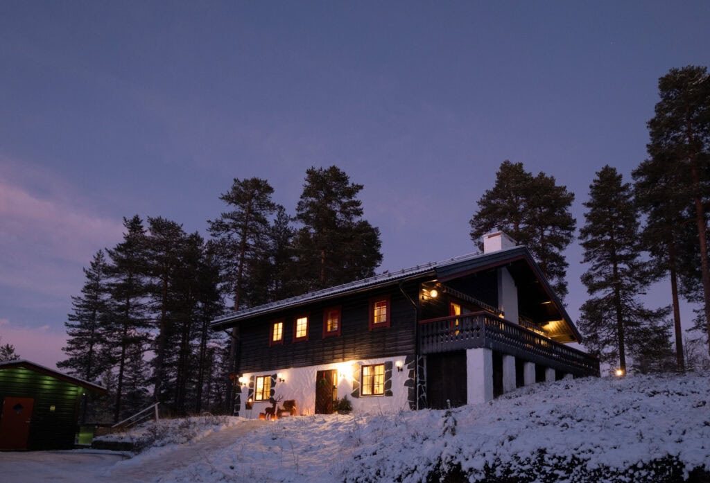 Vinterhus med snö och skog