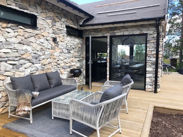Terrasse mit modernem Gartensofa und Stühlen vor einem Steinhaus – ideal zum Entspannen und für gesellige Anlässe.