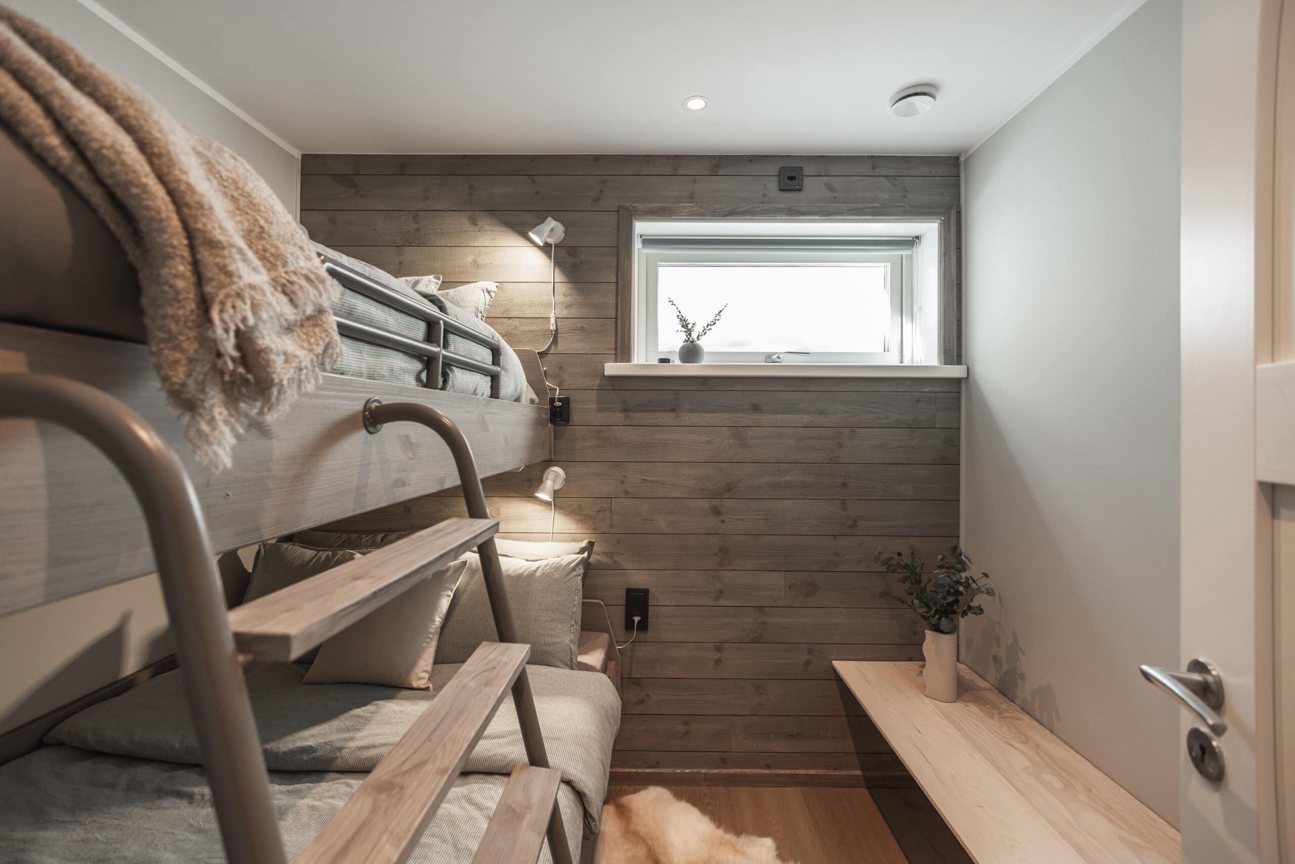 Mysigt sovrum med våningssäng, träväggar och naturliga inredningsdetaljer, perfekt för avkoppling och vila.
