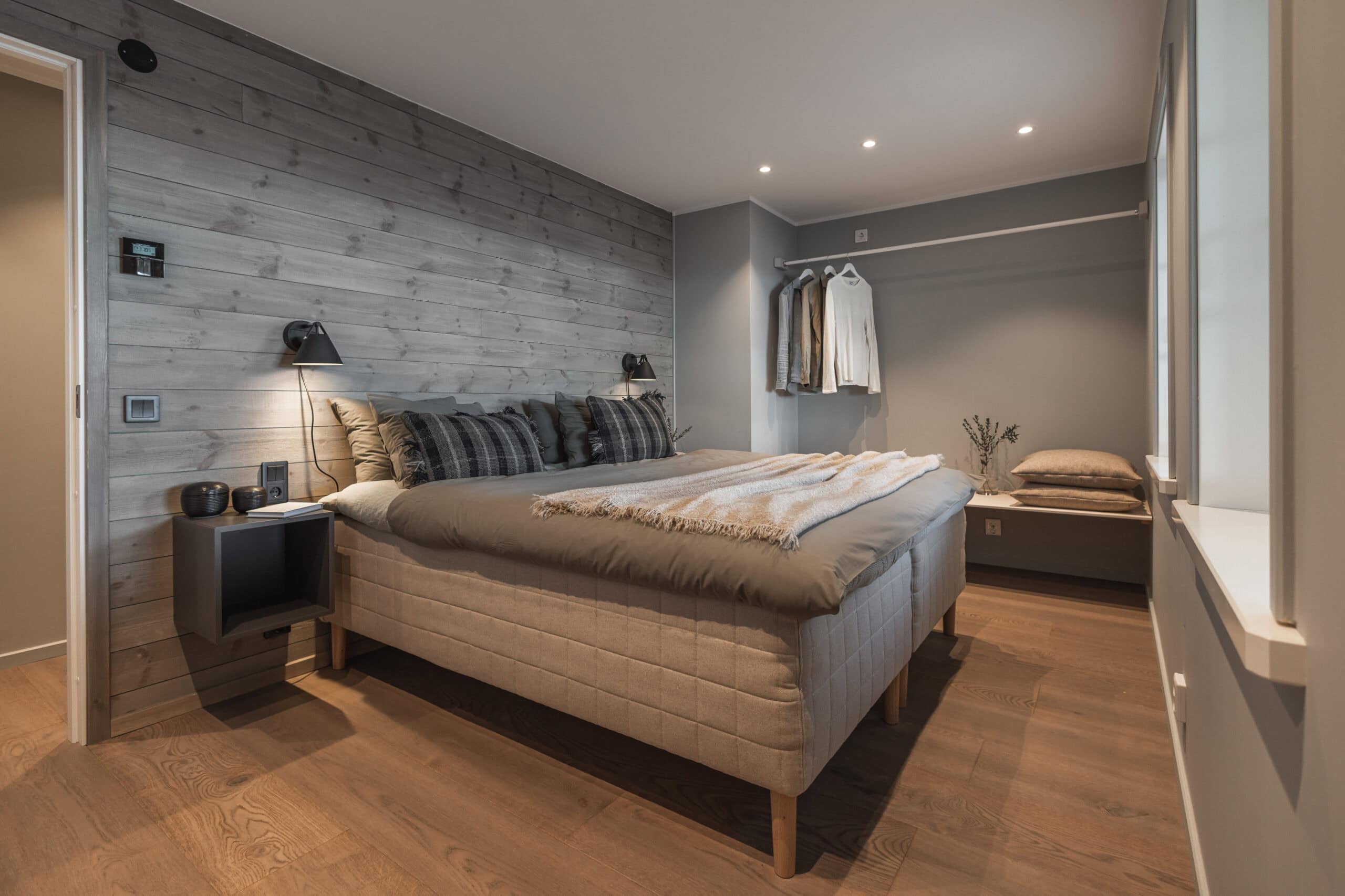 Modernt sovrum med trävägg, bekvämt sängkläder och minimalistisk inredning, perfekt för avkoppling och vila.