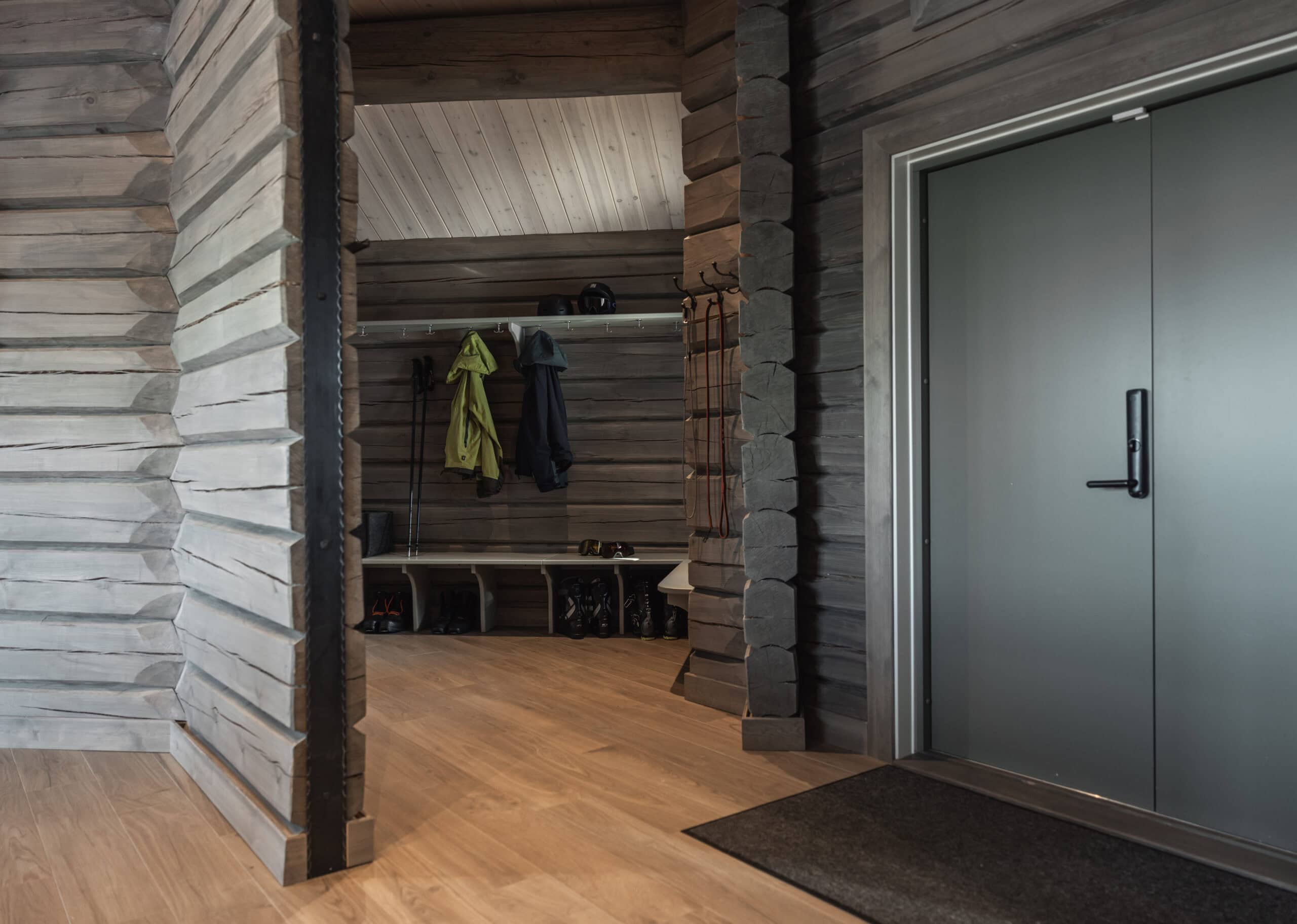 Modern entré med träväggar och mörkgrå dörr, rustik stil för Sälengodset.