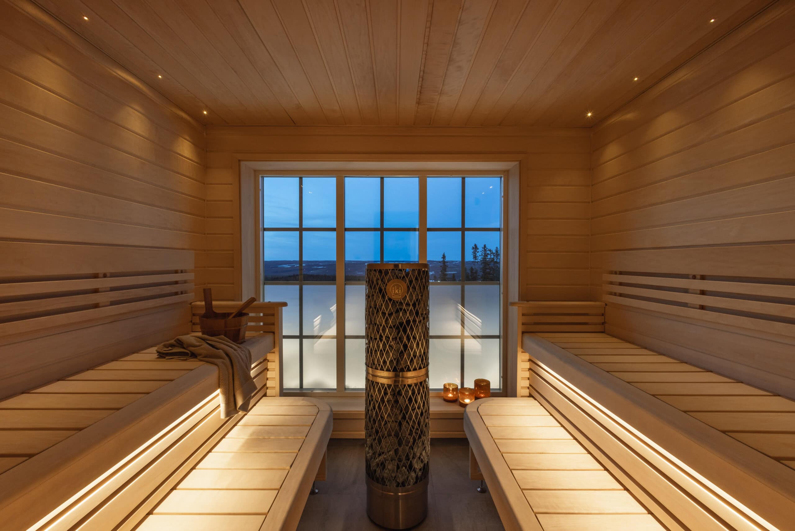 Salengodset inomhusbad med panoramafönster och träinteriör för avkoppling och wellness.