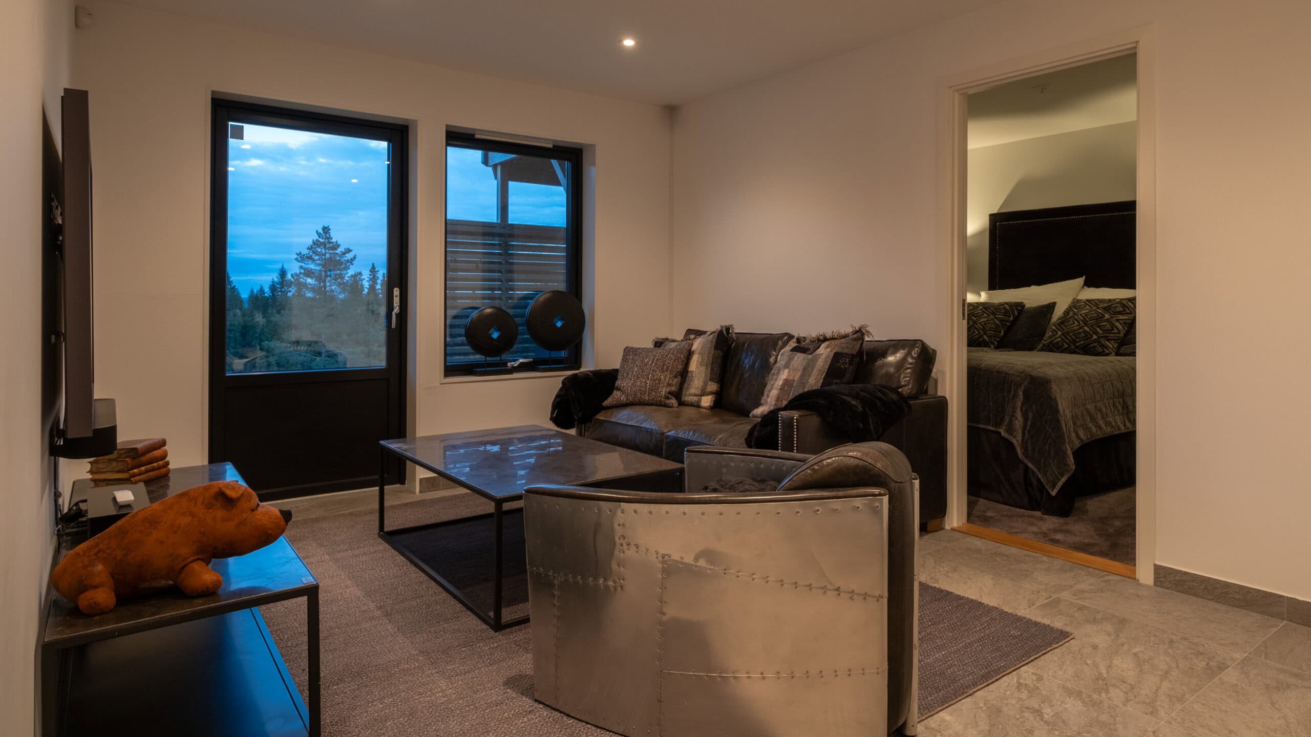 The family room on the ground floor, featuring a sofa suite, patio doors and access to one of the bedrooms.