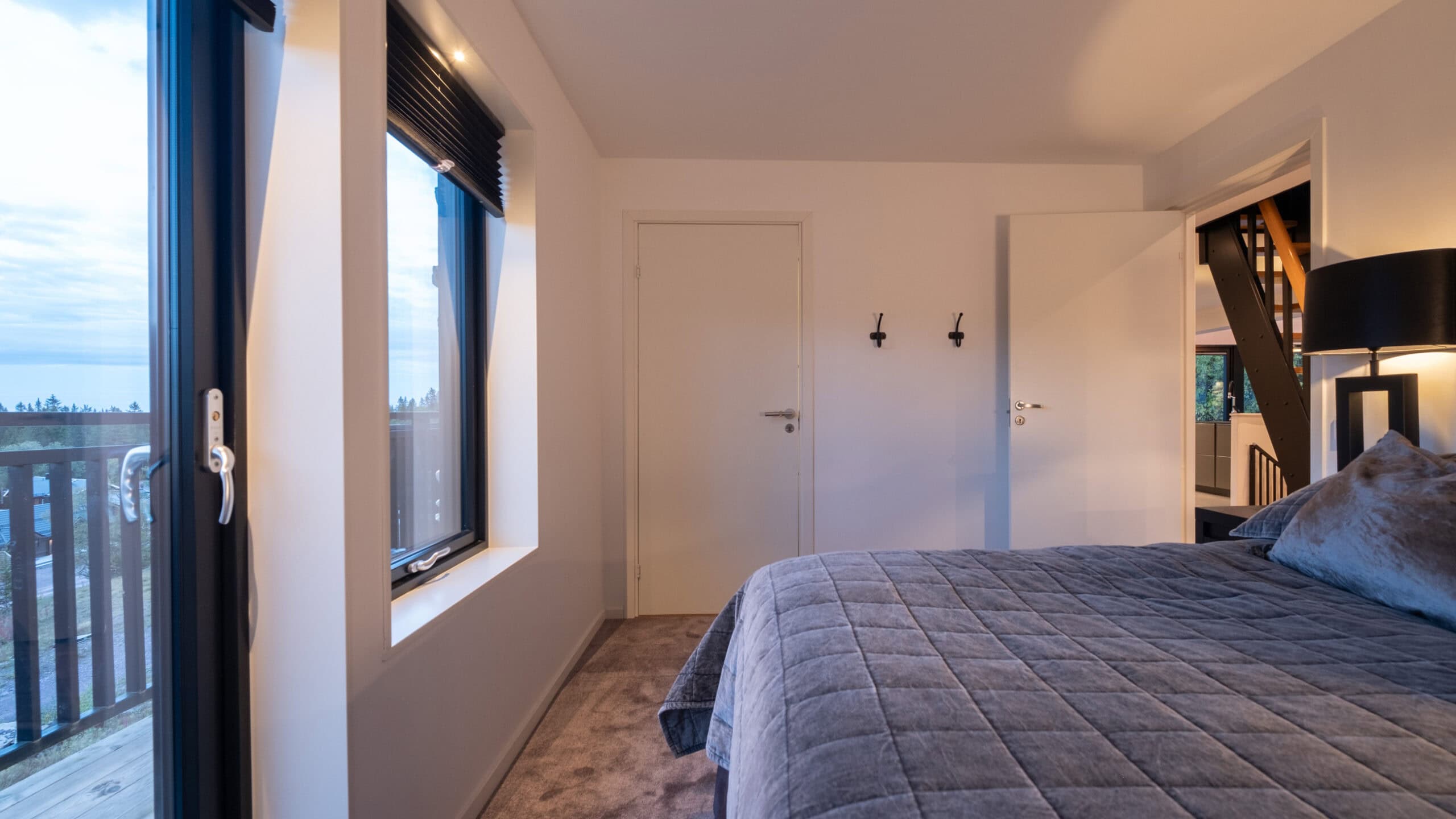 A bedroom with a double bed next to the French doors leading out onto the balcony.