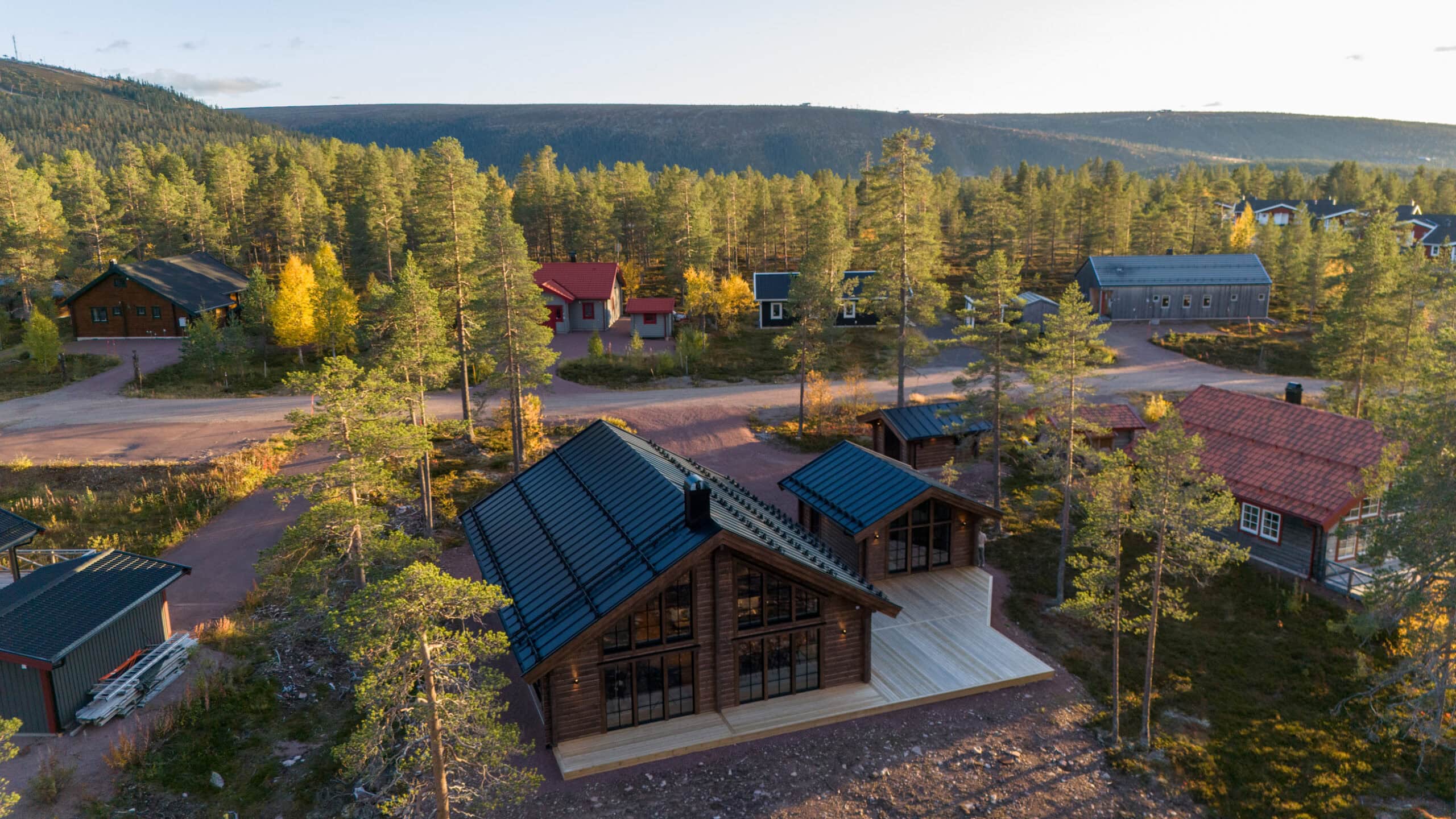 Huset från luften i solnedgång med skogen runt om