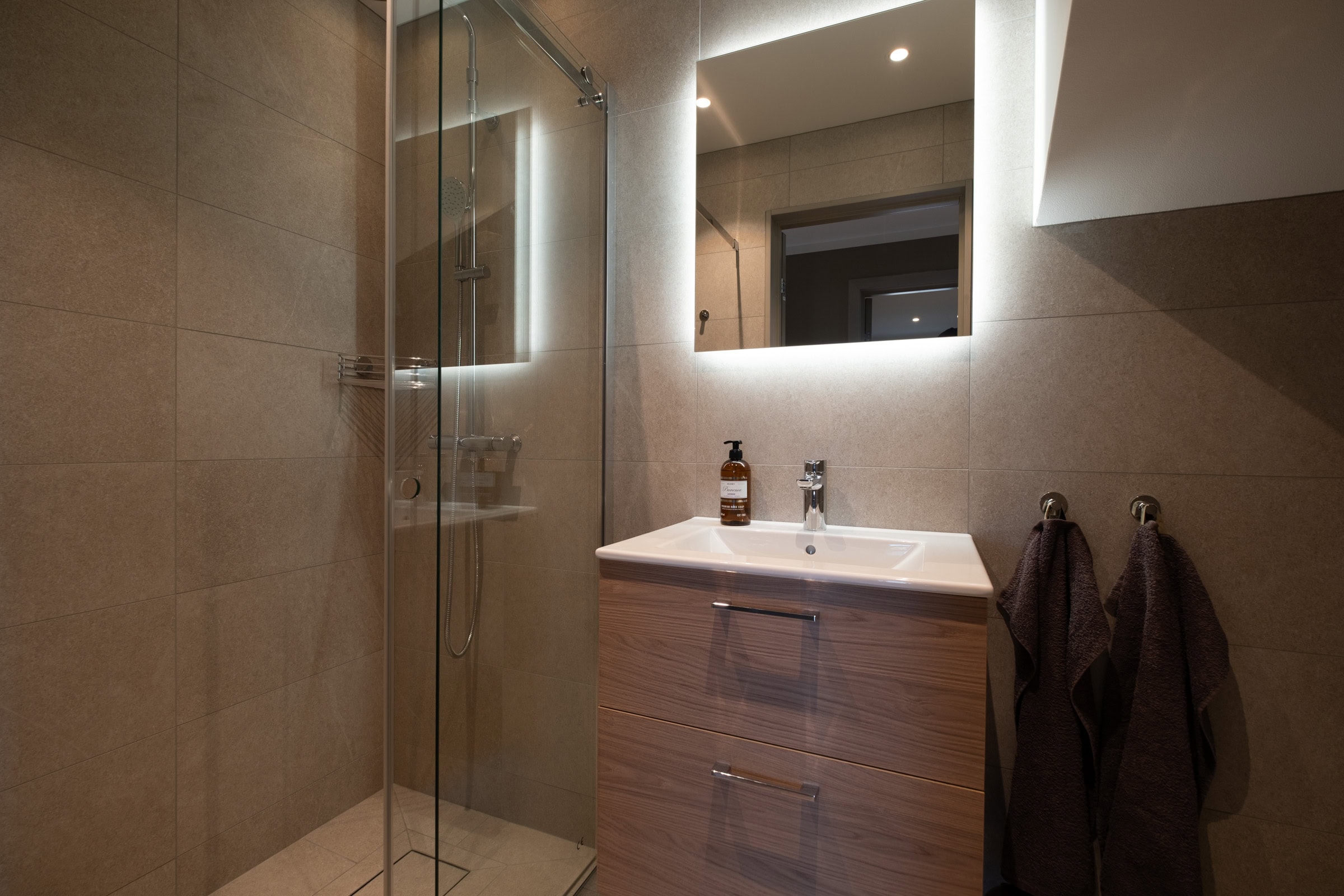 Shower room with a glass partition, washbasin and mirror