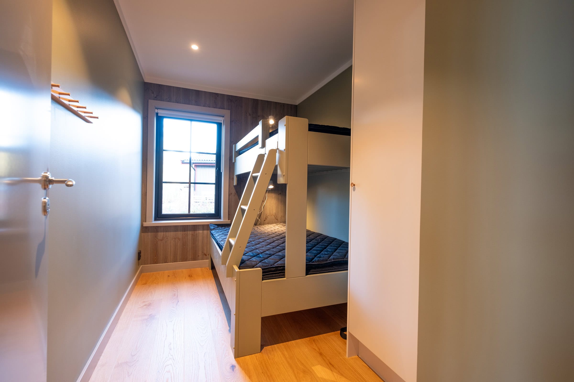 Bedroom with a bunk bed and a window overlooking the forest