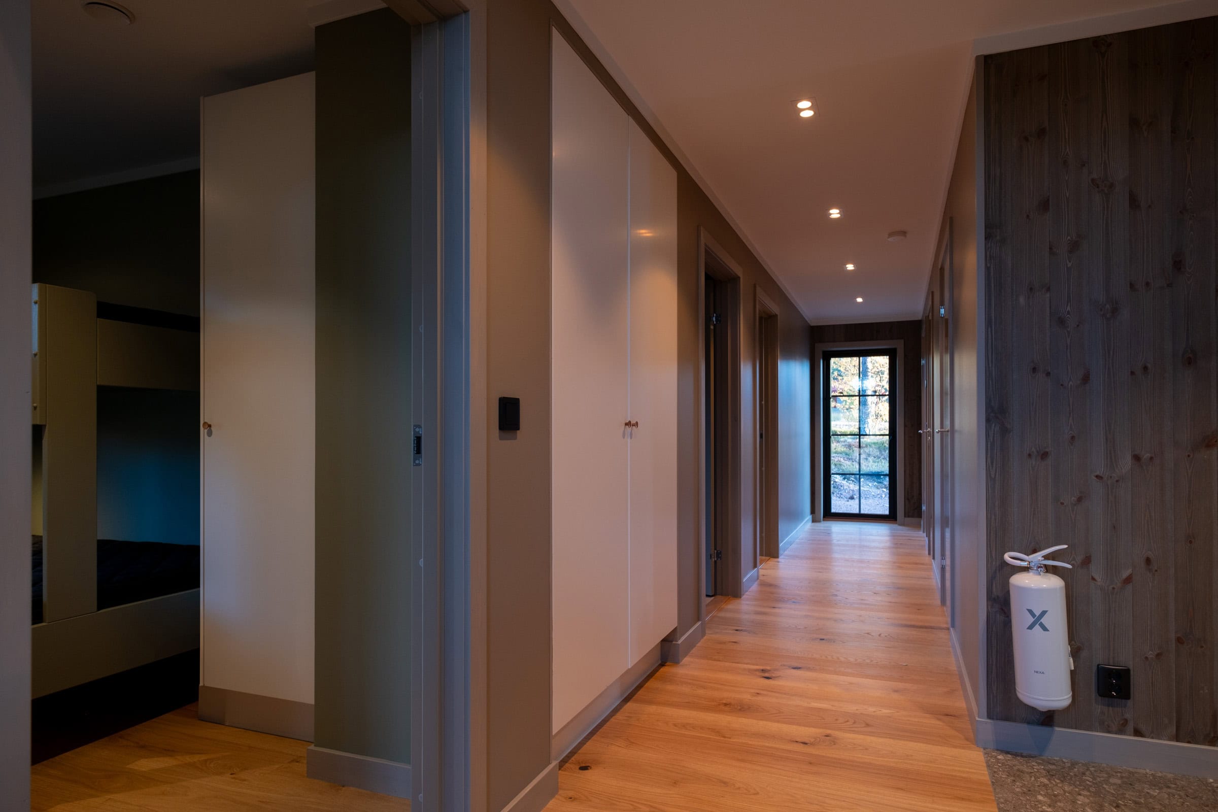 Hallway with wardrobes and oak flooring; a French door at the far end