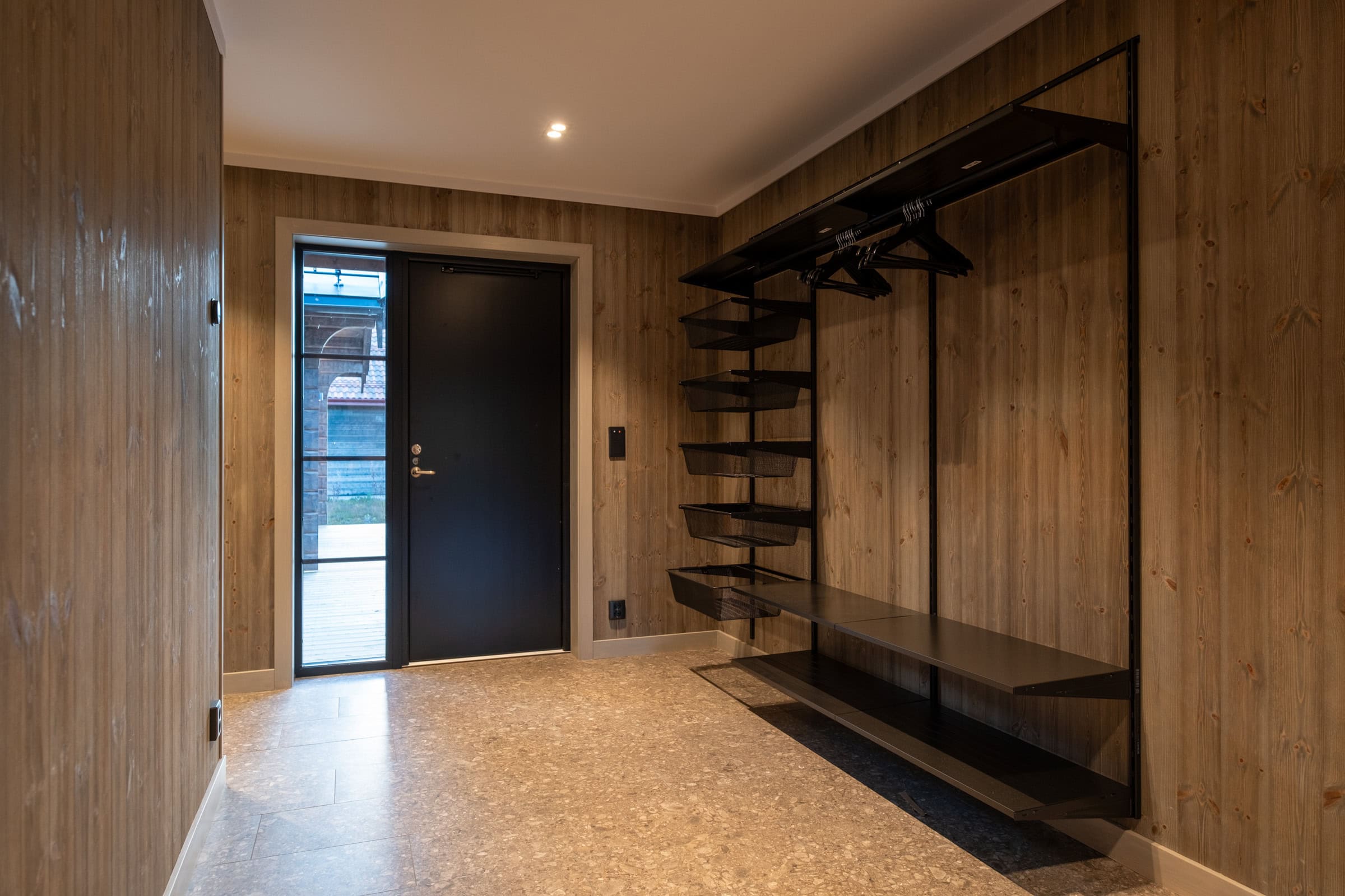 Hallway with wall-mounted storage for skis and ski boots