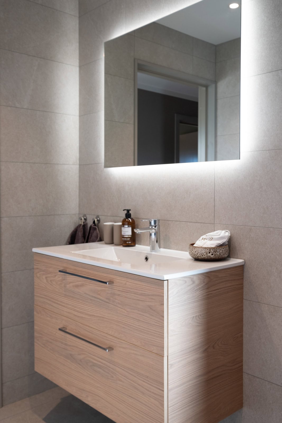 Washbasin with oak vanity unit and backlit mirror